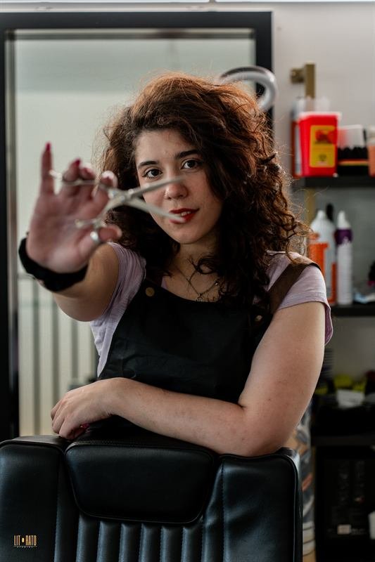 Anya, barber-stylist, holding scissors
